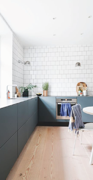 Kitchen with deep green cabinets and pale timber floor